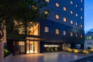 a building with a courtyard in front of it at The OneFive Marine Fukuoka in Fukuoka