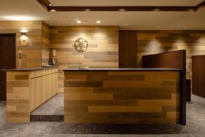 a lobby with a counter with wood paneling at The OneFive Marine Fukuoka in Fukuoka