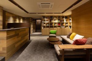 a lobby with a couch and chairs and a television at The OneFive Marine Fukuoka in Fukuoka