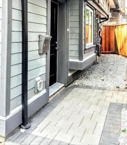 an open door to a house with a porch at New Urban Modern Main Street House in Vancouver