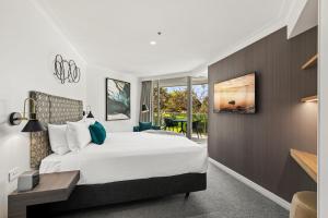 a bedroom with a large white bed and a window at Pullman Quay Grand Sydney Harbour in Sydney