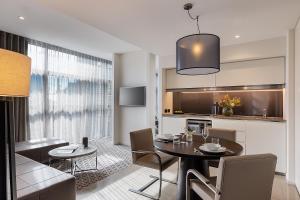 a dining room and kitchen with a table and chairs at Fraser Suites Sydney in Sydney