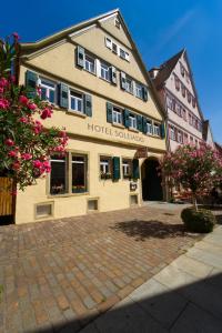 a hotel building with flowers in front of it at Soleiado Hotel in Bietigheim-Bissingen