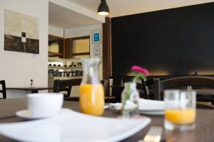 a table with a vase of orange juice on it at Soleiado Hotel in Bietigheim-Bissingen