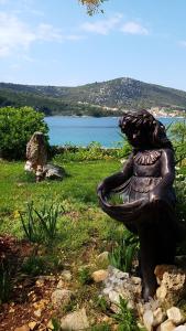 a statue of a woman sitting in a bird bath at Apartments Selina in Vinišće