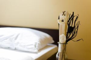 a vase filled with flowers sitting next to a bed at Opera Vama Veche in Vama Veche