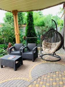 a patio with two chairs and a swing at Elit in Romny