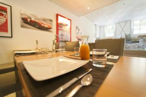 a dining room with a wooden table with a bottle and glasses at Hotel Reinhardts in Bietigheim-Bissingen