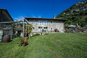 a stone house with a yard in front of it at Relais del Brigante in Settimo Vittone