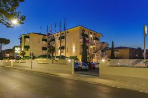 un edificio con coches estacionados en un estacionamiento por la noche en Hotel Liu, en Lido di Camaiore