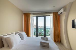 a hotel room with a bed and a large window at Orbi Beach Tower Hotel Official in Batumi