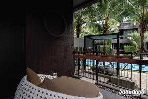 a room with a couch on a balcony with palm trees at OneBedroom with Balcony at Saturdays Residence in Rawai Beach