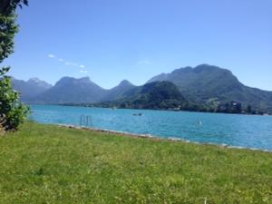 une grande étendue d'eau avec des montagnes en arrière-plan dans l'établissement Maison du Lac le Studio, à Talloires