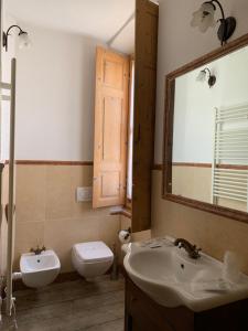 bagno con lavandino, servizi igienici e specchio di Relais Villa Brioschi ad Aprica
