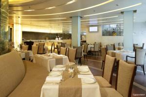 a dining room with white tables and chairs at Jaypee Siddharth in New Delhi