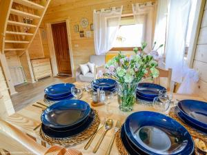 una mesa con placas azules y un jarrón de flores en Całoroczne Domki Zaciszna Polana, en Polanica-Zdrój