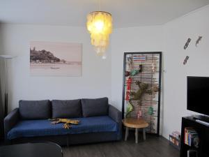 a living room with a blue couch and a chandelier at Bos en Lommer Hotel - Erasmus Park area in Amsterdam