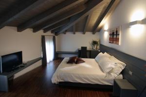 a bedroom with a bed and a flat screen tv at Albergo al Vecchio Tram in Udine