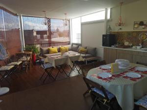 un soggiorno con tavoli e sedie e una cucina di Tortugas B&B a Giarre
