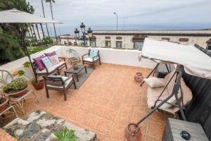 a balcony with chairs and tables and an umbrella at Casa Amparo in Icod de los Vinos