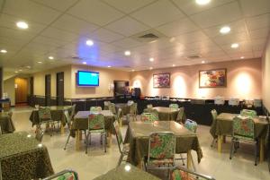 a dining room with tables and chairs and a flat screen tv at Tong Bing Express in Hsinchu City