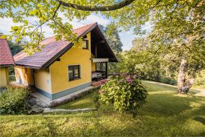 Country House Budana في Brestanica: منزل أصفر في ساحة بها زهور