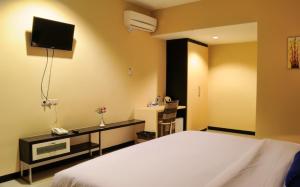 um quarto com uma cama, uma televisão e uma secretária em Amazing Beach Resort Palu em Palu