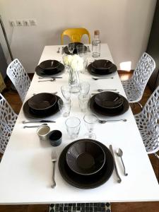 a white table with black plates and glasses on it at Entre Neige et Thermes in Brides-les-Bains