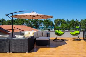 a patio with a couch and an umbrella and chairs at Magnetic Resort Ureki in Ureki