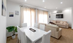 ein Wohnzimmer mit einem weißen Tisch und einem Sofa in der Unterkunft Maka beach apartment v in Castelldefels