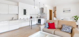 a living room with a couch and a kitchen at Maka beach apartment v in Castelldefels