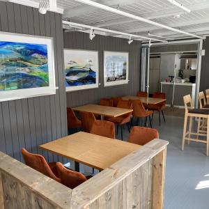 a room with tables and chairs and paintings on the walls at Bergtun Hotell in Valle +1 photo