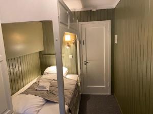 a bedroom with a bunk bed and a door to a room at Bergtun Hotell in Valle