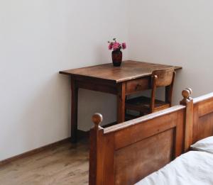 une table avec un vase de fleurs au-dessus d'un lit dans l'établissement Bahnhof 123, à Fridingen an der Donau