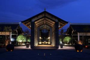 a building with a lit up front at night at Pullman Lijiang Resort & Spa in Lijiang
