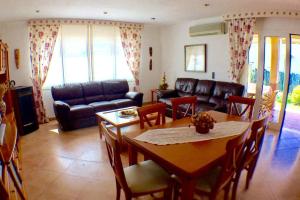 a living room with a table and a couch at Villa Sirena in Cala en Blanes