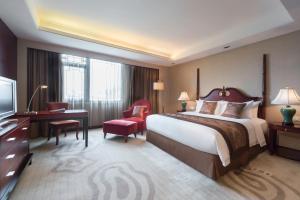 a hotel room with a bed and a desk and a television at Wyndham Garden Suzhou in Suzhou
