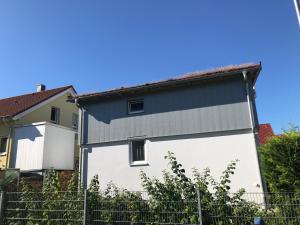 un bâtiment blanc et bleu avec une clôture dans l'établissement Schöne & ruhige Ferienwohnung, à Pfullingen