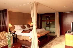 1 dormitorio con cama con dosel y sofá en Wyndham Garden Suzhou en Suzhou