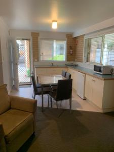 cocina y sala de estar con mesa y sofá en Port Campbell Parkview Motel & Apartments en Port Campbell