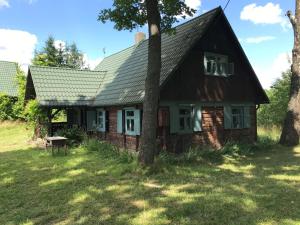 una vecchia casa con un albero di fronte di Suwalskie siedlisko a Szlinokiemie