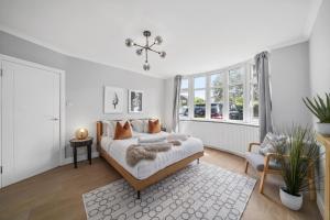 a white bedroom with a bed and a chair at Clarence House-Windsor-Parking-5 bed in Windsor