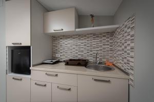 a kitchen with a sink and a microwave at Studio Apartments Bulevar in Podgorica