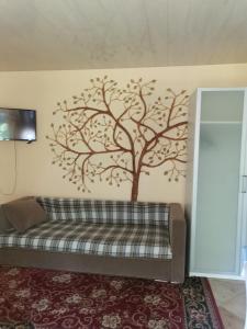 a tree stencil on a wall with a couch at Czerwonki agroturystyka u Beaty in Czerwonki
