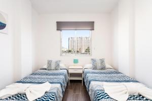 dwa łóżka w małym pokoju z oknem w obiekcie Home2Book Beautiful Apart Los Cristianos Pool Wifi w mieście Los Cristianos