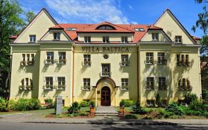 un grande edificio giallo con tetto rosso di Hotel Villa Baltica a Sopot