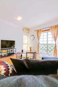 een woonkamer met een bank en een tv bij The Nest Apartment - Sea View - Faro in Faro