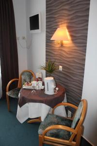 une chambre avec une table, des chaises et une lampe dans l'établissement Hotel-Restaurant Feldkamp, 