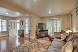 a living room with a couch and a flat screen tv at Creekside Home with Patio, Walk to Manitou Incline! in Manitou Springs