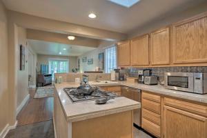 a large kitchen with wooden cabinets and a stove top oven at Creekside Home with Patio, Walk to Manitou Incline! in Manitou Springs